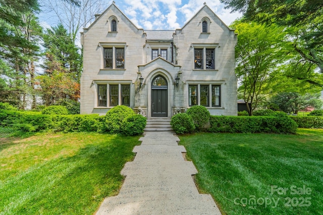 view of front of house with stone siding and a front lawn