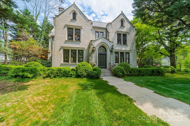 view of front of house with stone siding and a front lawn