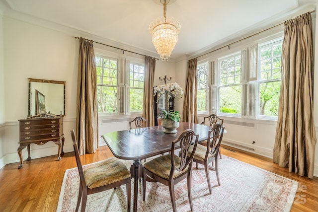 dining room with light wood-style flooring, a wealth of natural light, and a notable chandelier