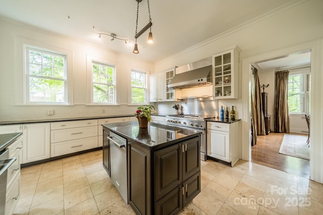 kitchen with range with two ovens, ornamental molding, wall chimney exhaust hood, tasteful backsplash, and glass insert cabinets