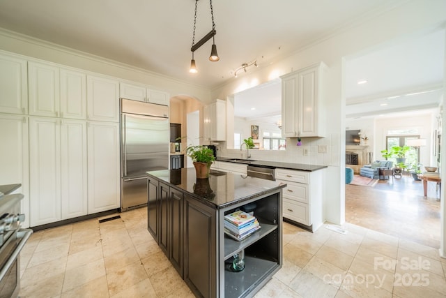 kitchen with appliances with stainless steel finishes, a wealth of natural light, a sink, and tasteful backsplash