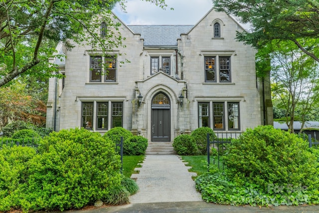 french provincial home with a high end roof and stone siding