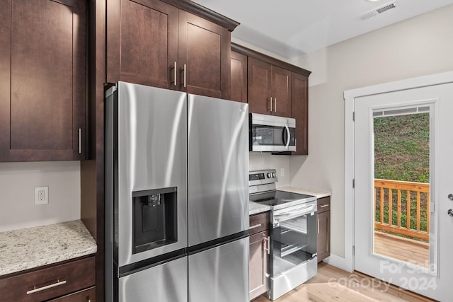 kitchen featuring light hardwood / wood-style floors, dark brown cabinets, light stone countertops, and appliances with stainless steel finishes