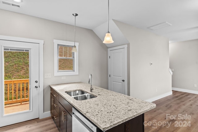 kitchen featuring kitchen peninsula, hanging light fixtures, sink, stainless steel dishwasher, and light hardwood / wood-style flooring