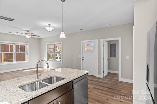 kitchen featuring dishwasher, hanging light fixtures, sink, and light hardwood / wood-style flooring