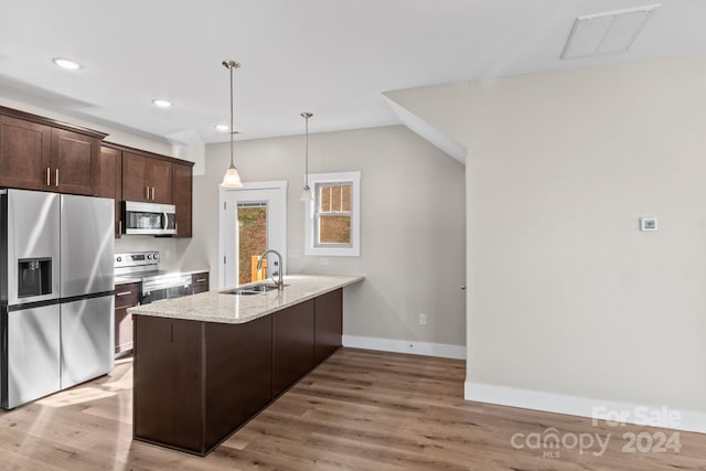 kitchen with stainless steel appliances, dark brown cabinets, light wood-type flooring, and kitchen peninsula