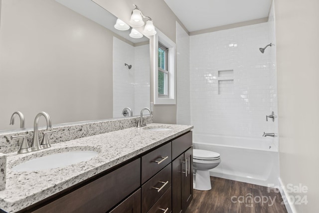 full bathroom with toilet, tiled shower / bath combo, vanity, and hardwood / wood-style flooring