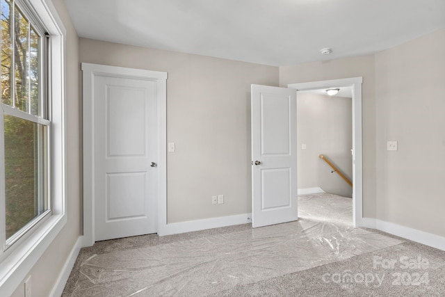 unfurnished bedroom featuring light carpet