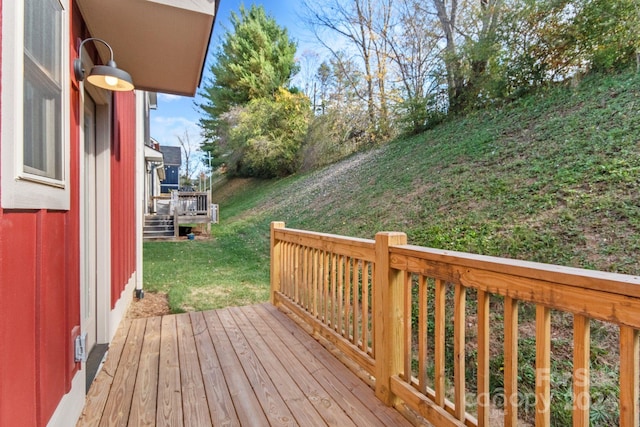 wooden deck featuring a lawn