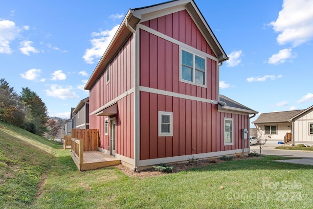 view of property exterior featuring a wooden deck and a yard