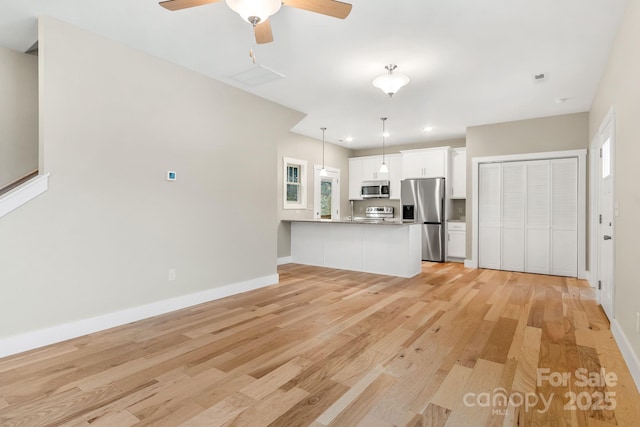 92 Wheeler Rd, Weaverville, NC 28787 - kitchen with stainless steel appliances, a peninsula, light wood finished floors, white cabinets, and plenty of natural light