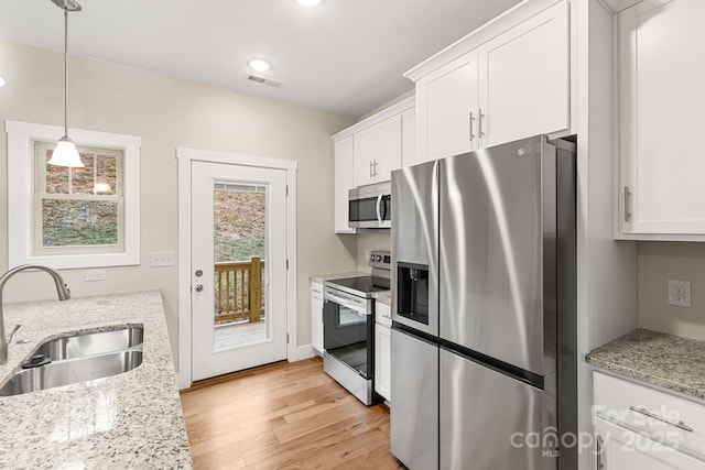 92 Wheeler Rd, Weaverville, NC 28787 - kitchen with stainless steel appliances, a sink, light wood-style floors, white cabinets, and light stone countertops