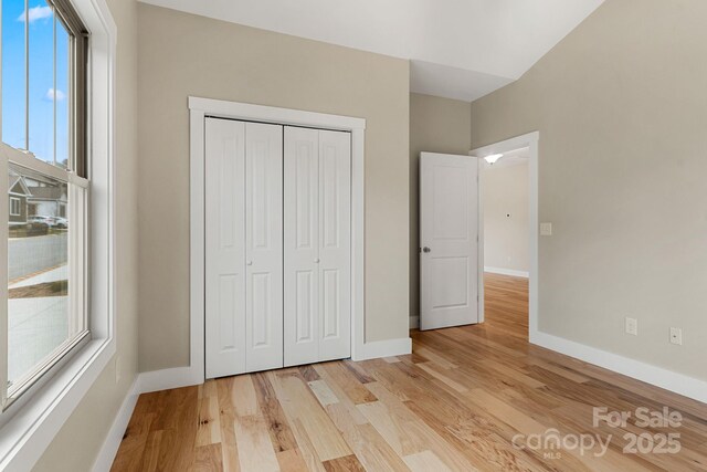 92 Wheeler Rd, Weaverville, NC 28787 - unfurnished bedroom featuring light wood-style flooring, baseboards, and a closet
