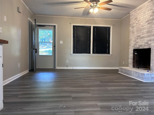 unfurnished living room with ornamental molding, dark wood-type flooring, a fireplace, and a textured ceiling