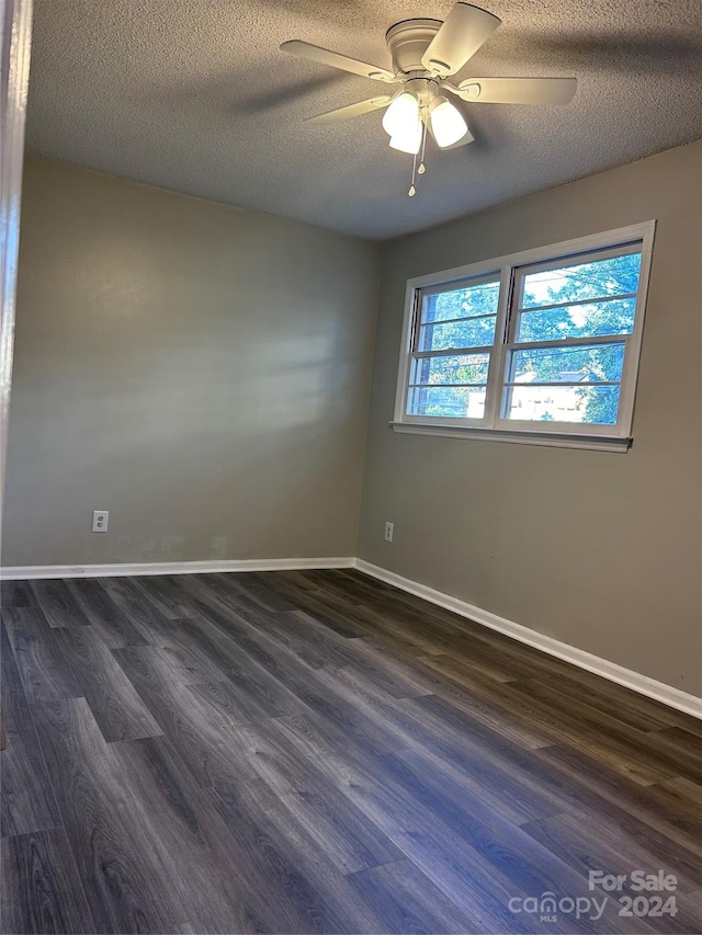 spare room with a textured ceiling, ceiling fan, and dark hardwood / wood-style flooring