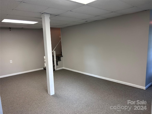 basement with dark carpet and a paneled ceiling