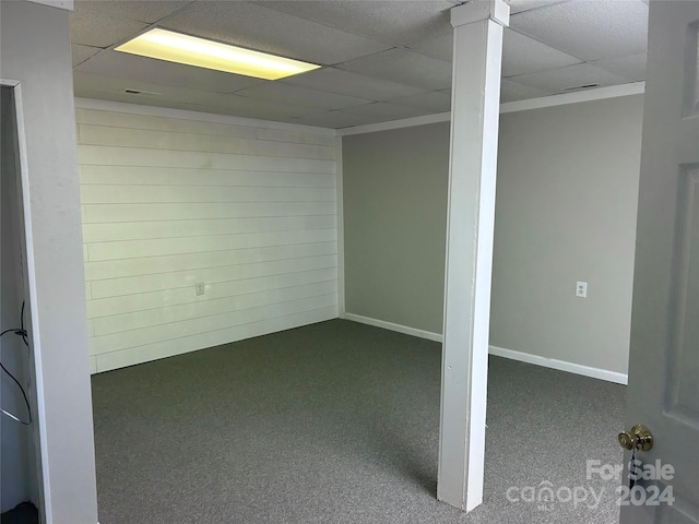 basement featuring a paneled ceiling and carpet