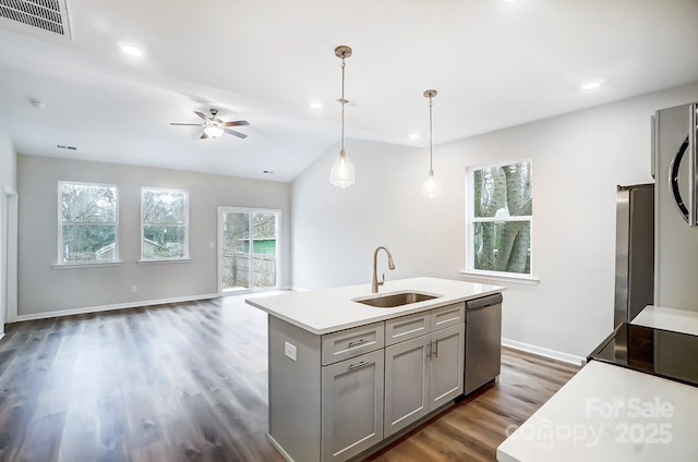 kitchen with pendant lighting, a kitchen island with sink, sink, and stainless steel dishwasher