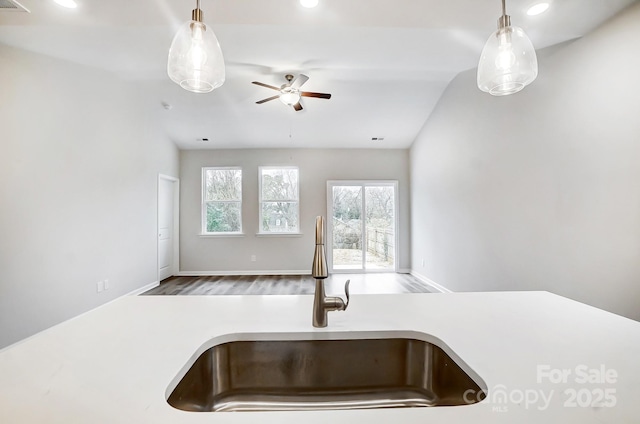 kitchen with hardwood / wood-style floors, lofted ceiling, sink, hanging light fixtures, and ceiling fan