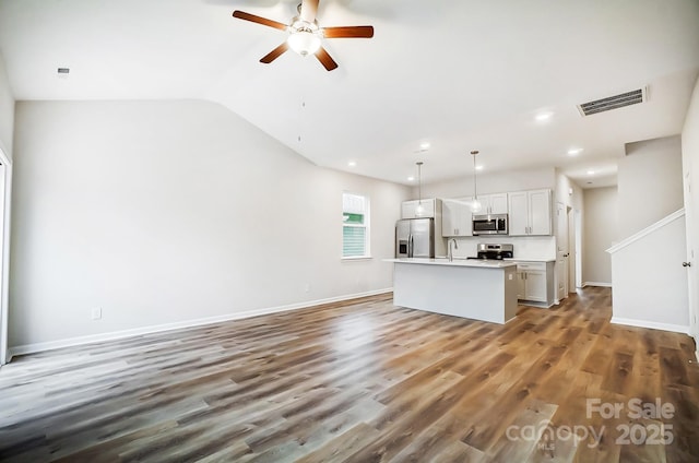 unfurnished living room featuring vaulted ceiling, ceiling fan, dark wood-type flooring, and sink