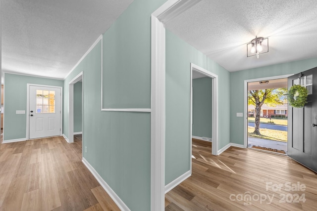 foyer with a textured ceiling, light hardwood / wood-style floors, and plenty of natural light