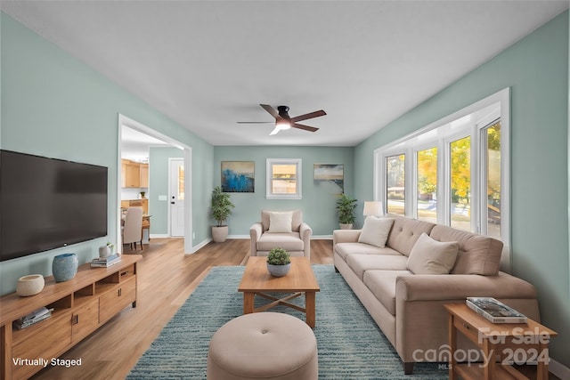 living room with light hardwood / wood-style flooring and ceiling fan