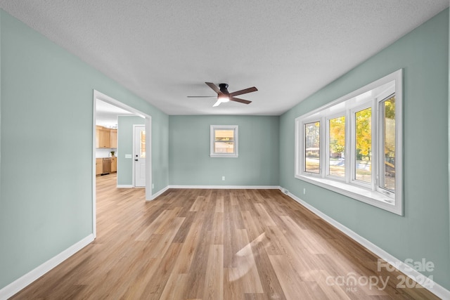 unfurnished room featuring light hardwood / wood-style floors, a textured ceiling, and ceiling fan