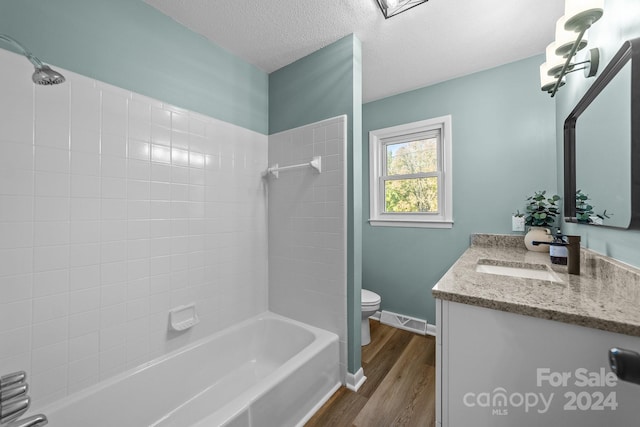 full bathroom with vanity, toilet, tiled shower / bath combo, and wood-type flooring