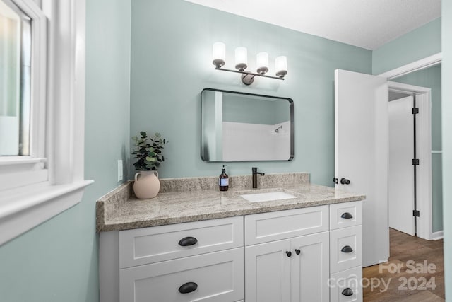 bathroom with vanity, hardwood / wood-style floors, and a textured ceiling