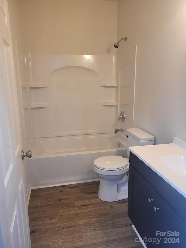 full bathroom with hardwood / wood-style floors, vanity, toilet, and washtub / shower combination