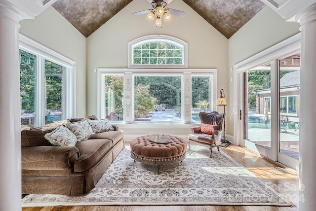 sunroom with ceiling fan, vaulted ceiling, and decorative columns