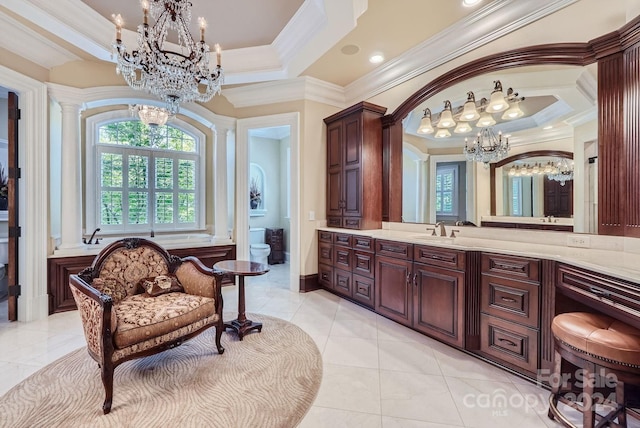 bathroom featuring an inviting chandelier, toilet, ornate columns, vanity, and crown molding