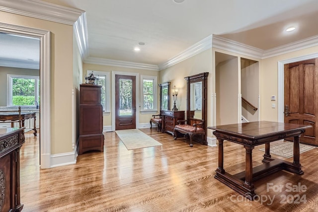 foyer with light wood-type flooring, crown molding, and plenty of natural light