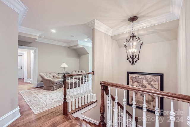 hallway featuring ornamental molding, hardwood / wood-style floors, and a chandelier