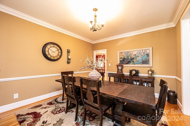 dining area featuring ornamental molding, hardwood / wood-style floors, and an inviting chandelier