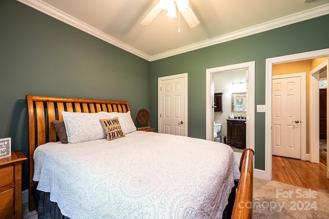 bedroom with connected bathroom, hardwood / wood-style floors, crown molding, and ceiling fan