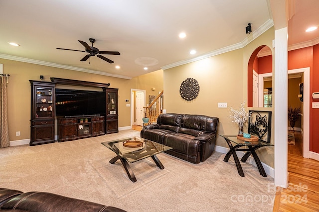 living room featuring crown molding, light wood-type flooring, and ceiling fan