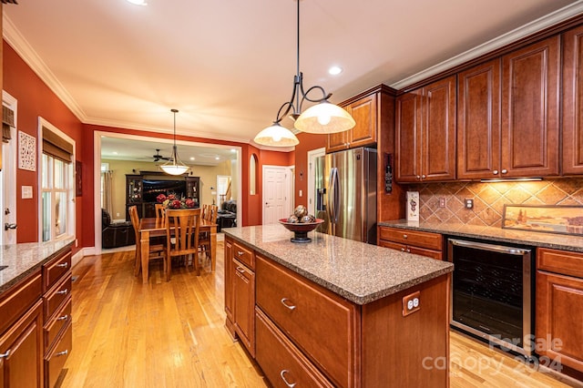 kitchen featuring light hardwood / wood-style flooring, hanging light fixtures, wine cooler, a center island, and stainless steel fridge with ice dispenser