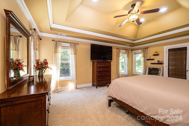 carpeted bedroom with ceiling fan, a raised ceiling, and crown molding