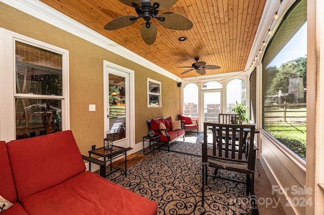 sunroom featuring ceiling fan, a healthy amount of sunlight, and wooden ceiling