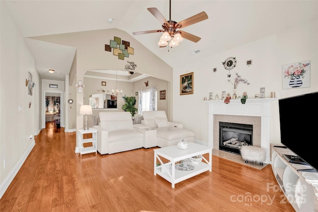 living room featuring ceiling fan, high vaulted ceiling, and wood-type flooring