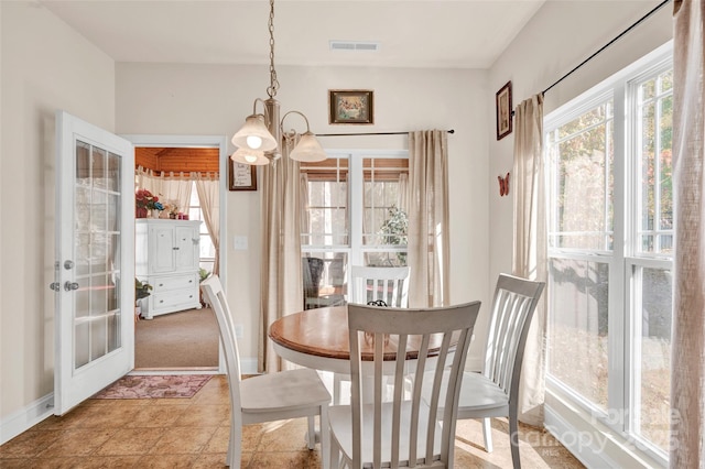 carpeted dining area with a notable chandelier