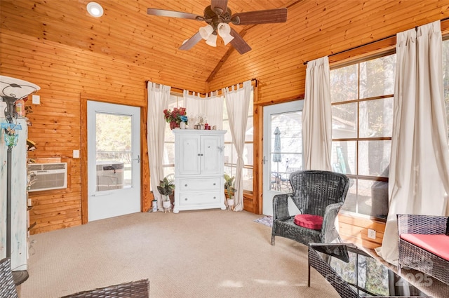 living area with carpet, ceiling fan, wood walls, and wooden ceiling