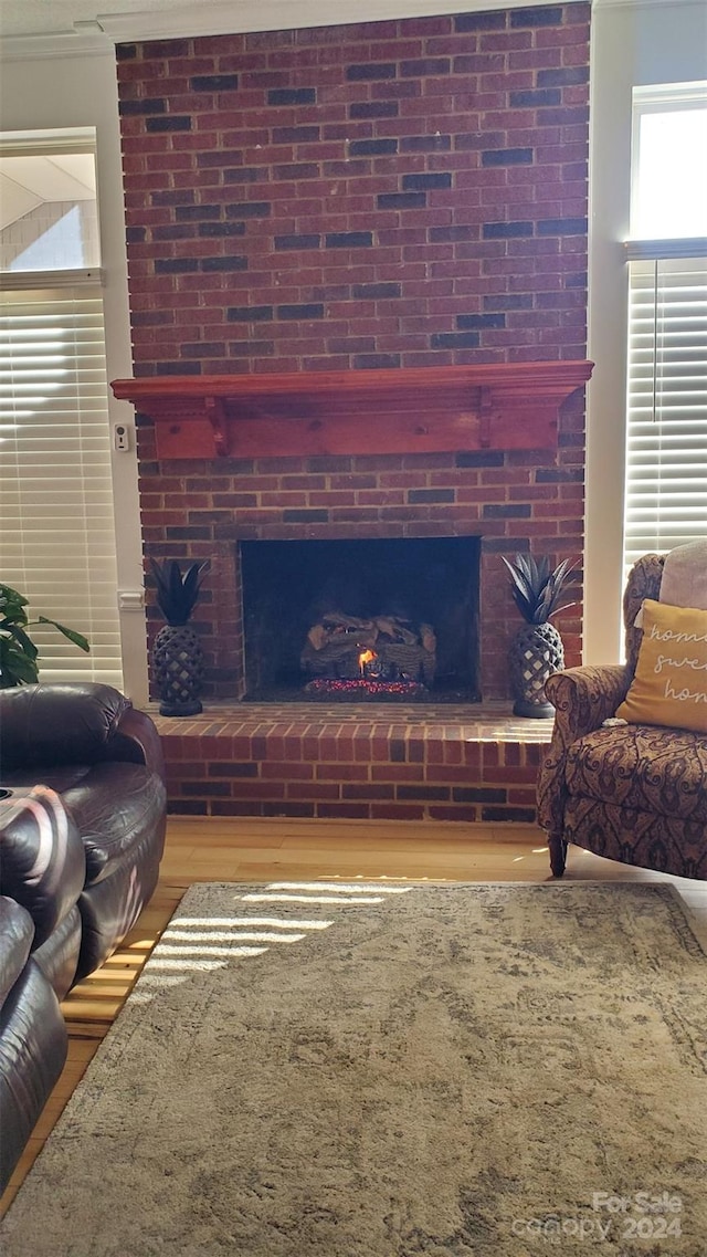 living room with hardwood / wood-style floors and a brick fireplace