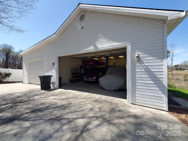 detached garage featuring fence