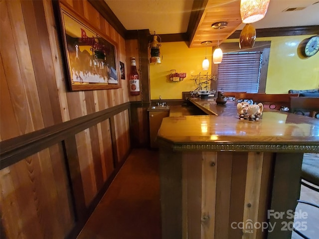 bar with a sink, wood walls, beamed ceiling, and visible vents