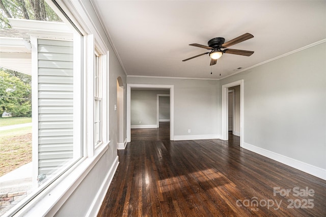 spare room with ceiling fan, a wealth of natural light, crown molding, and dark hardwood / wood-style flooring