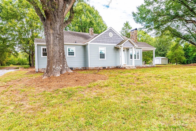 view of front of property with a shed and a front lawn