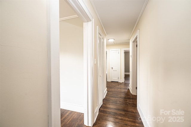 corridor with dark wood-type flooring and crown molding