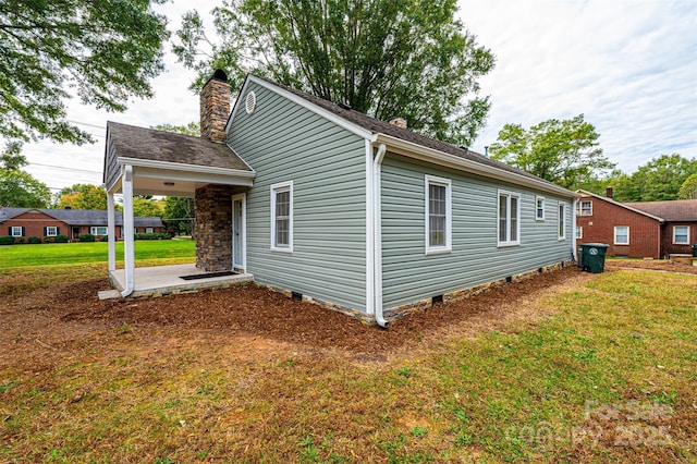 view of property exterior with a yard and a patio